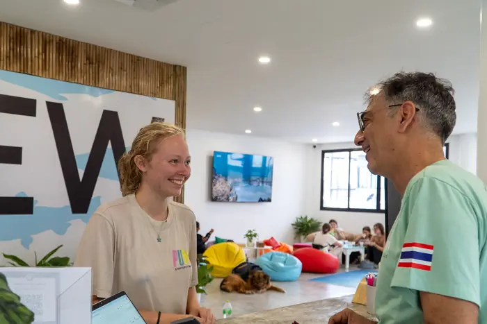 Un huésped en recepción con una empleada sonriente