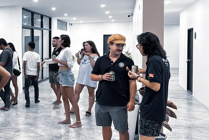 Huéspedes reunidos en el lobby por la noche, con una copa en la mano