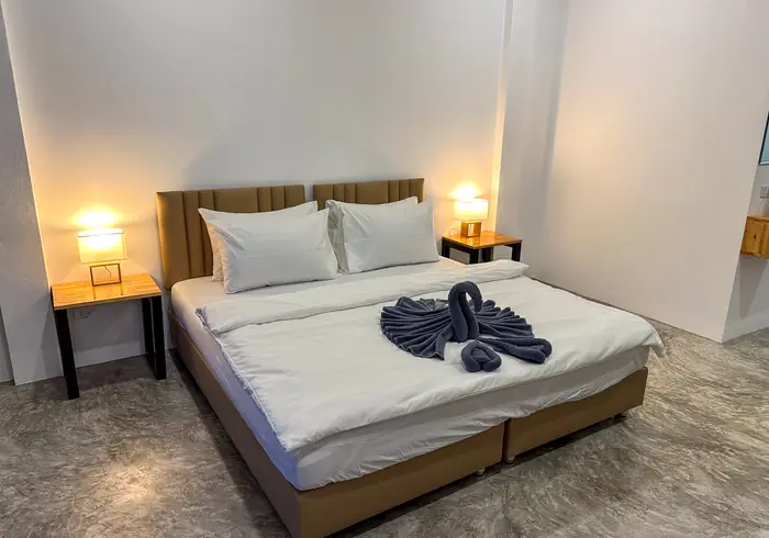 King bed with warm bedside lamps and a swan towel sculpture
