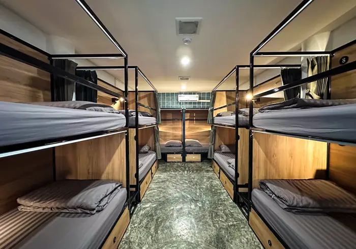 Symmetrical central aisle between bunks, glass-block window at the end