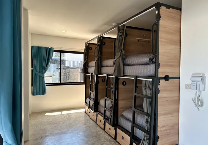 The bunks beside the window, with teal curtain and daylight