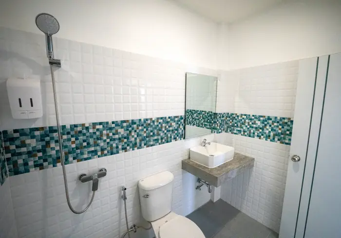 Private bathroom with shower and turquoise mosaic band