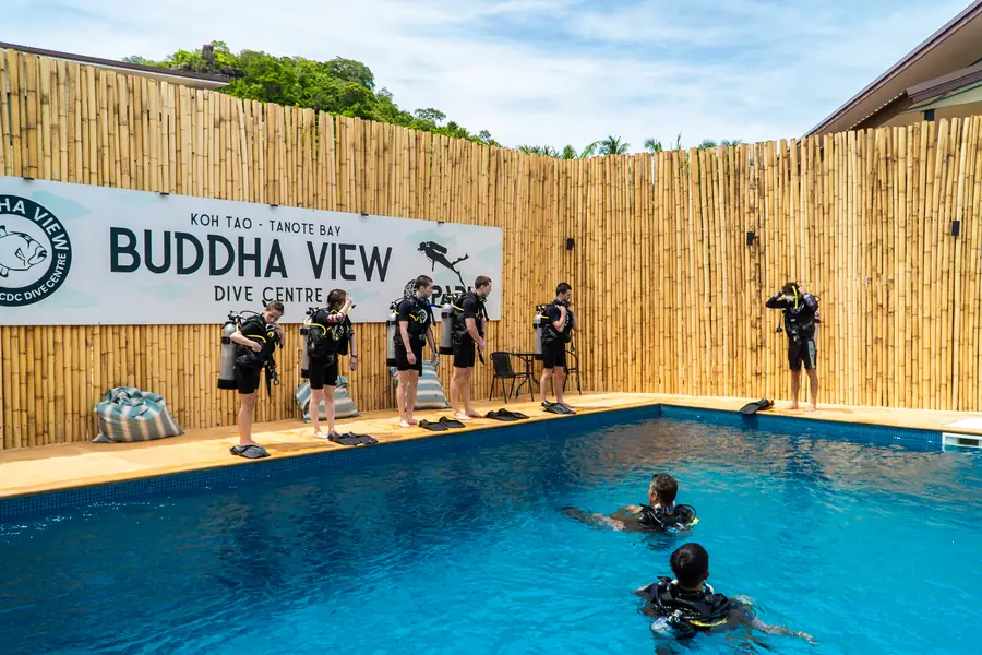 Students in full scuba gear lined up along the poolside before a session