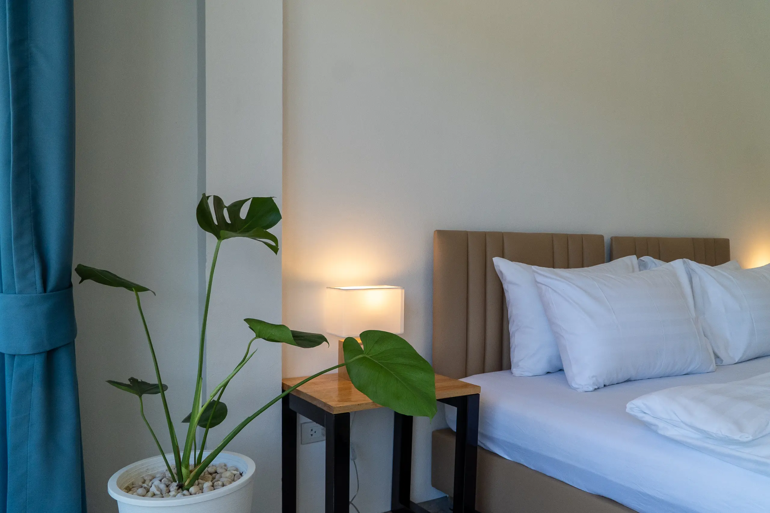 Twin beds with bedside lamps and balcony opening onto the jungle hillside