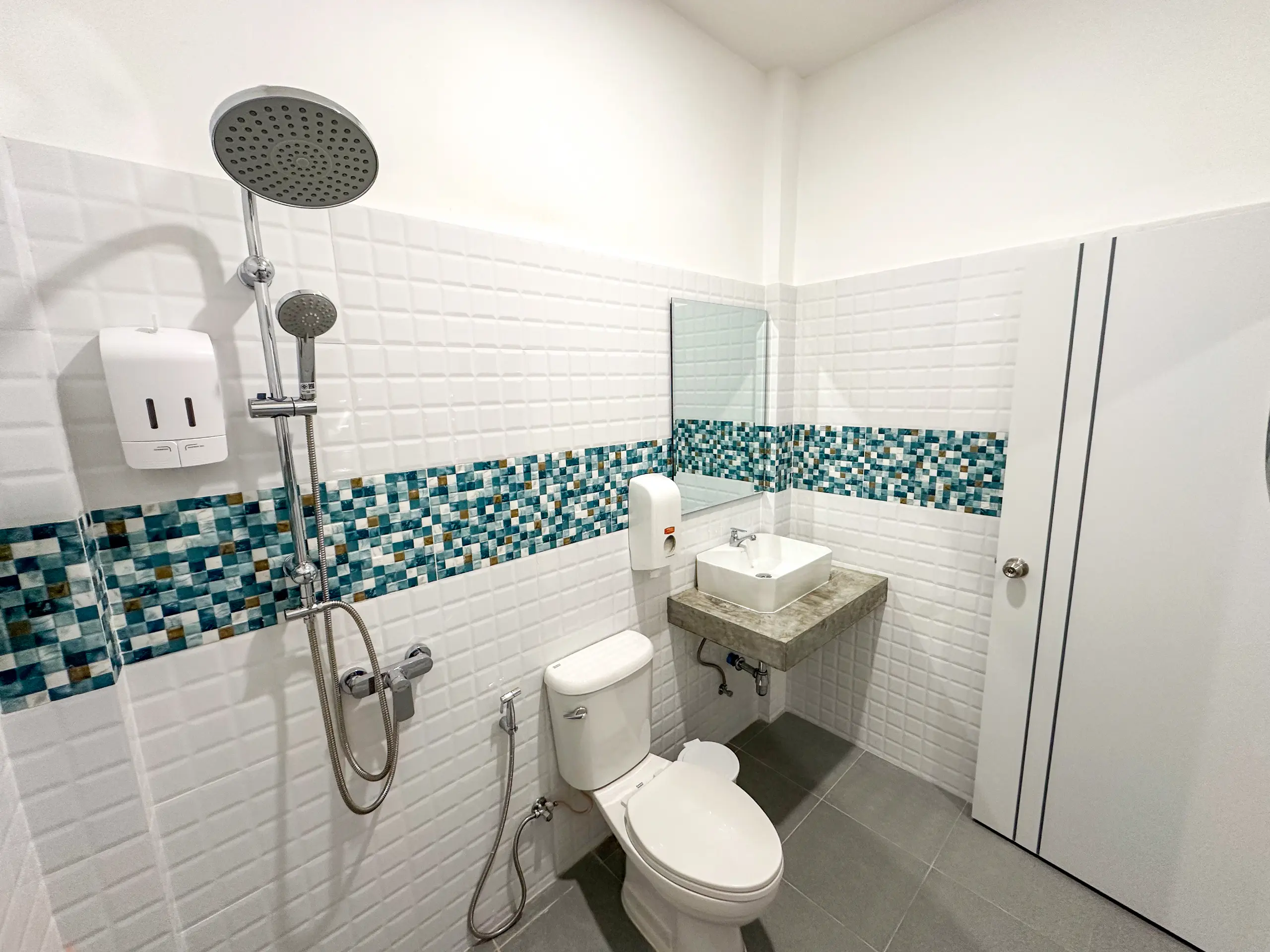 Private bathroom with rain shower and turquoise mosaic band
